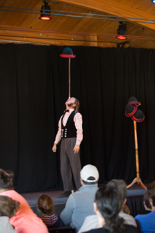 Slim balancing a hat and cane on his nose