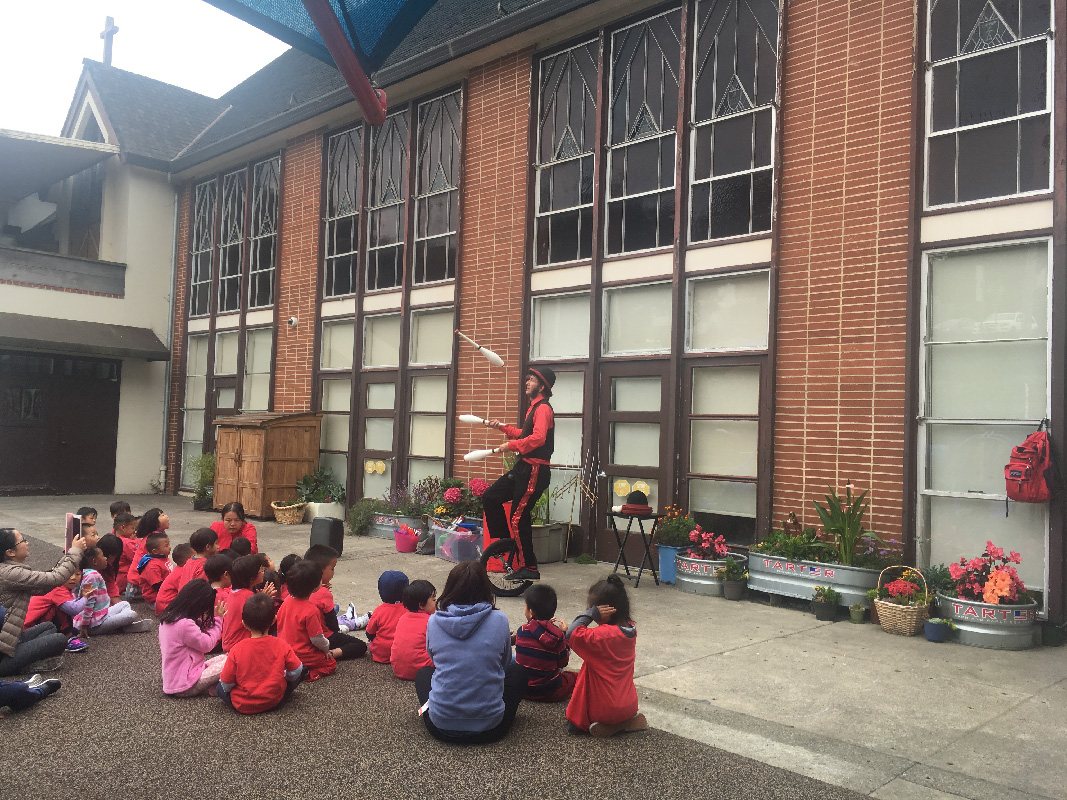 Slim juggling pins on a unicycle for young schoolchildren